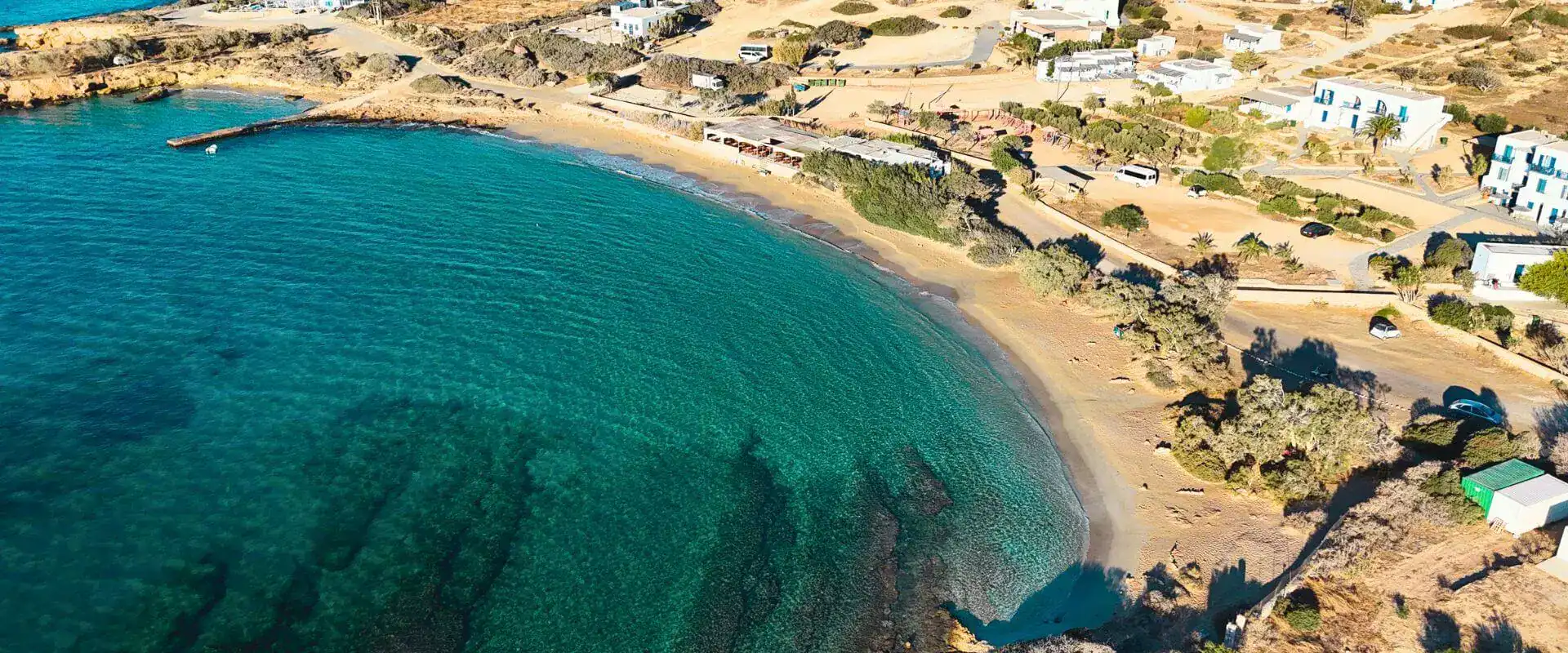 Aerial drone view of Foinikas Beach in Koufonisia island with calm blue waters and golden sand