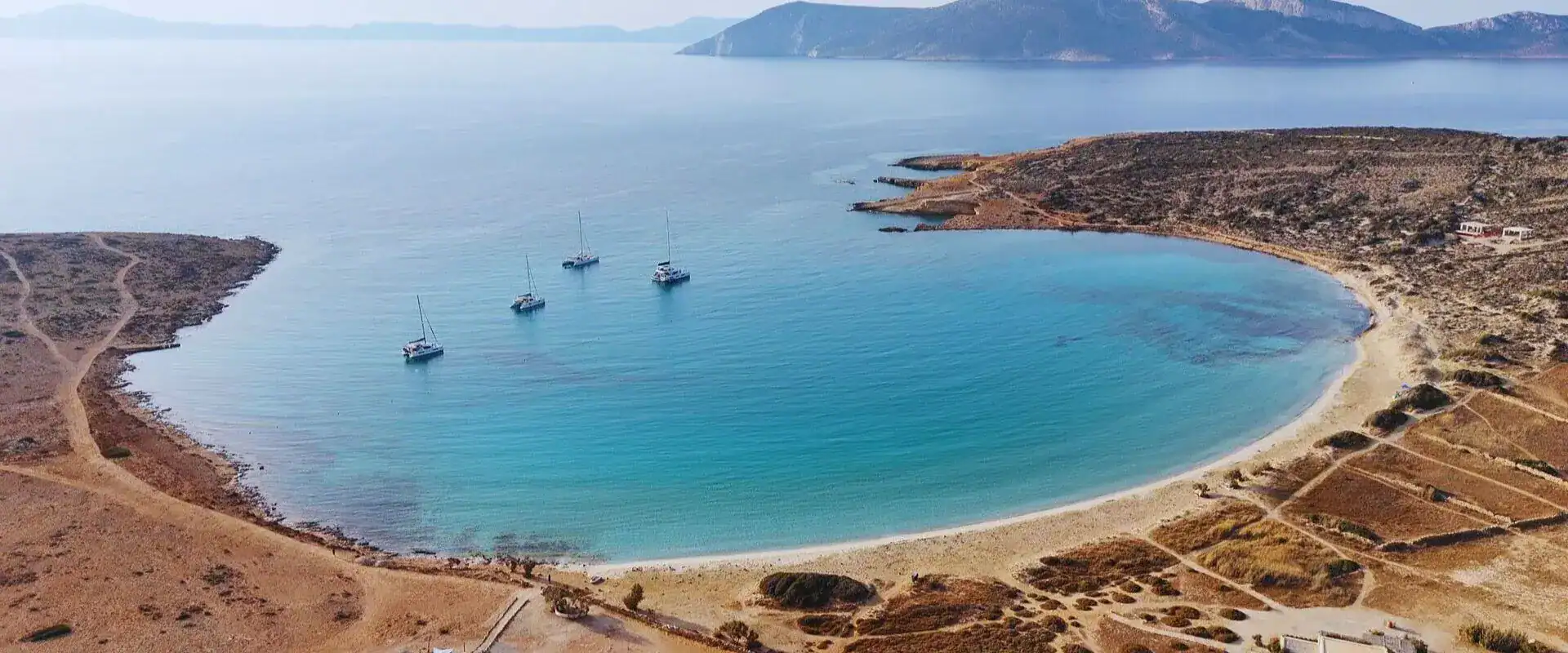 Aerial drone view of Pori Beach in Koufonisia island with crystal-clear turquoise water and white sand