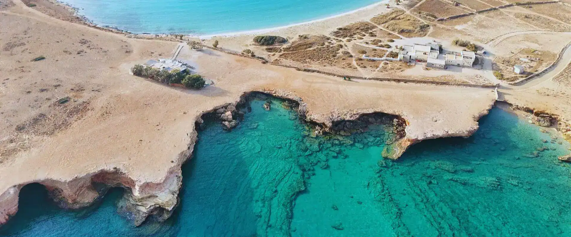 View of Xilompatis Beach in Koufonisia island with rocky coastline and crystal-clear turquoise sea